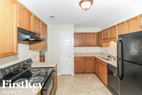 A kitchen with wooden cabinets and black appliances.