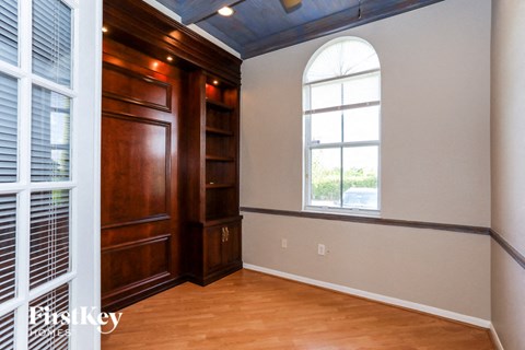 a bedroom with a window and wood flooring and a wooden closet