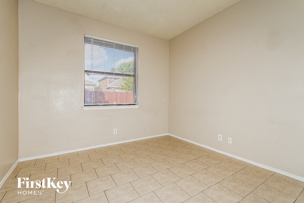 A room with a window and a tiled floor.