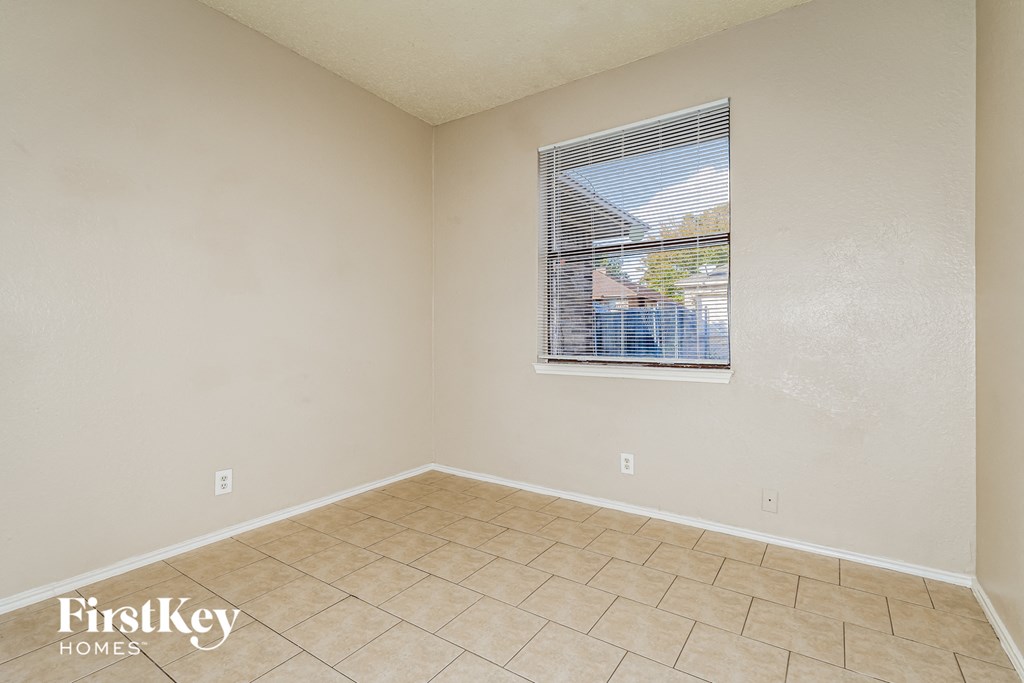 A room with a window and a tiled floor.