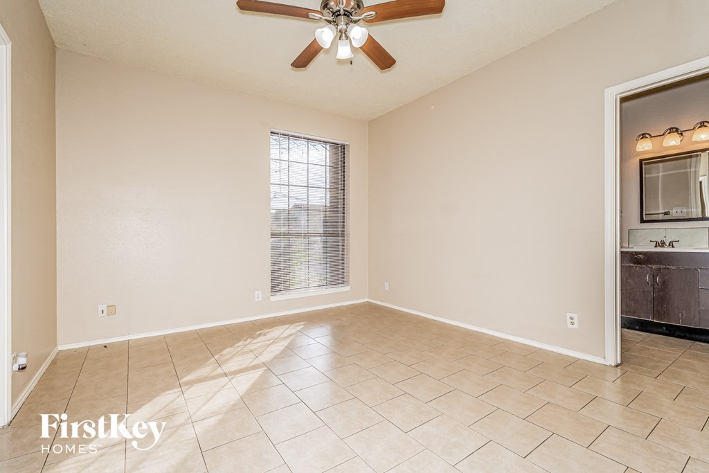 A spacious room with a ceiling fan and a window.