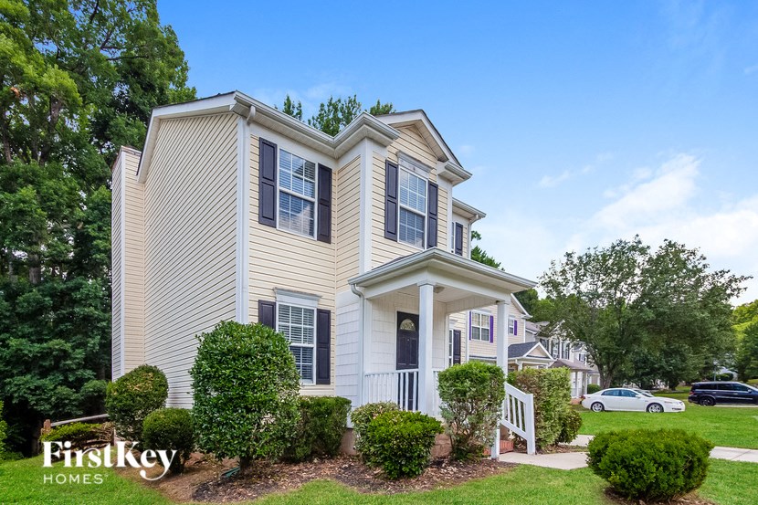 a white house with a lawn and trees