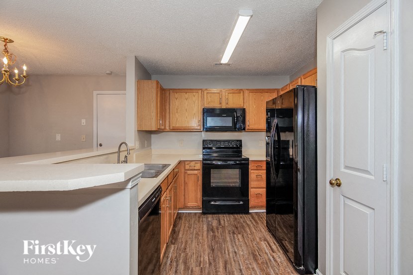 a kitchen with wood flooring and black appliances