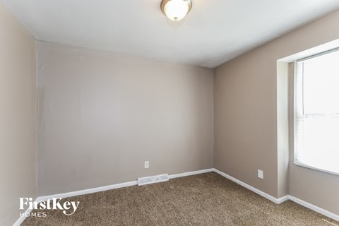a bedroom with a carpeted floor and a window