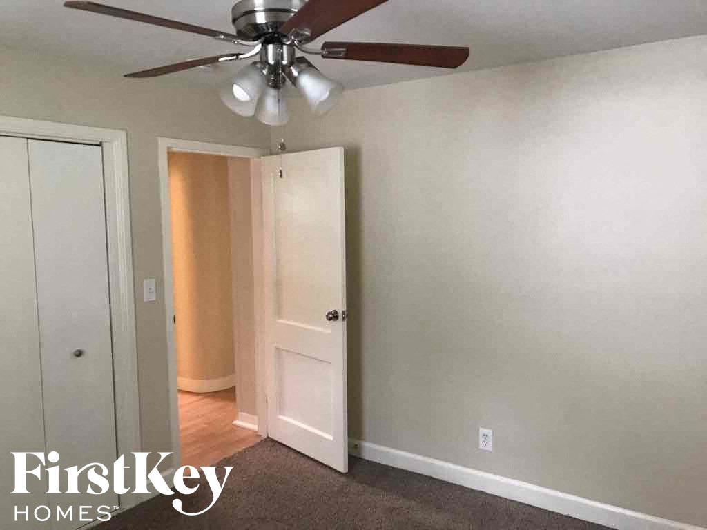 a room with a ceiling fan and a door to a closet