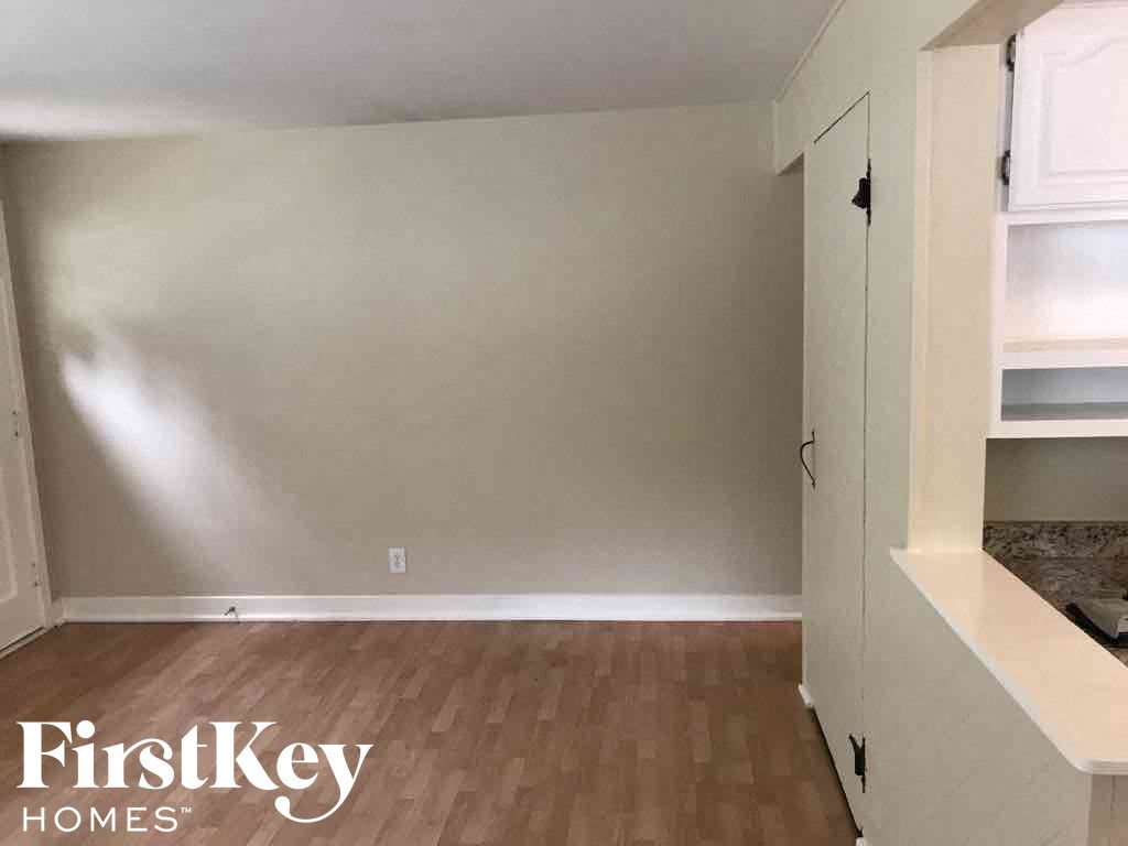 a empty room with a wooden floor and white cabinets