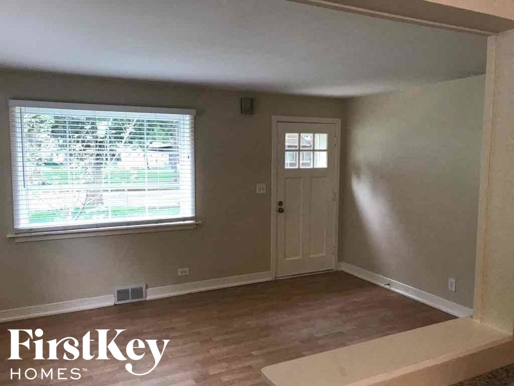 an empty living room with a window and a door
