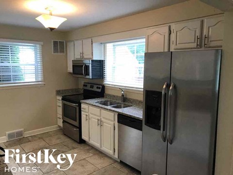 a kitchen with stainless steel appliances and white cabinets