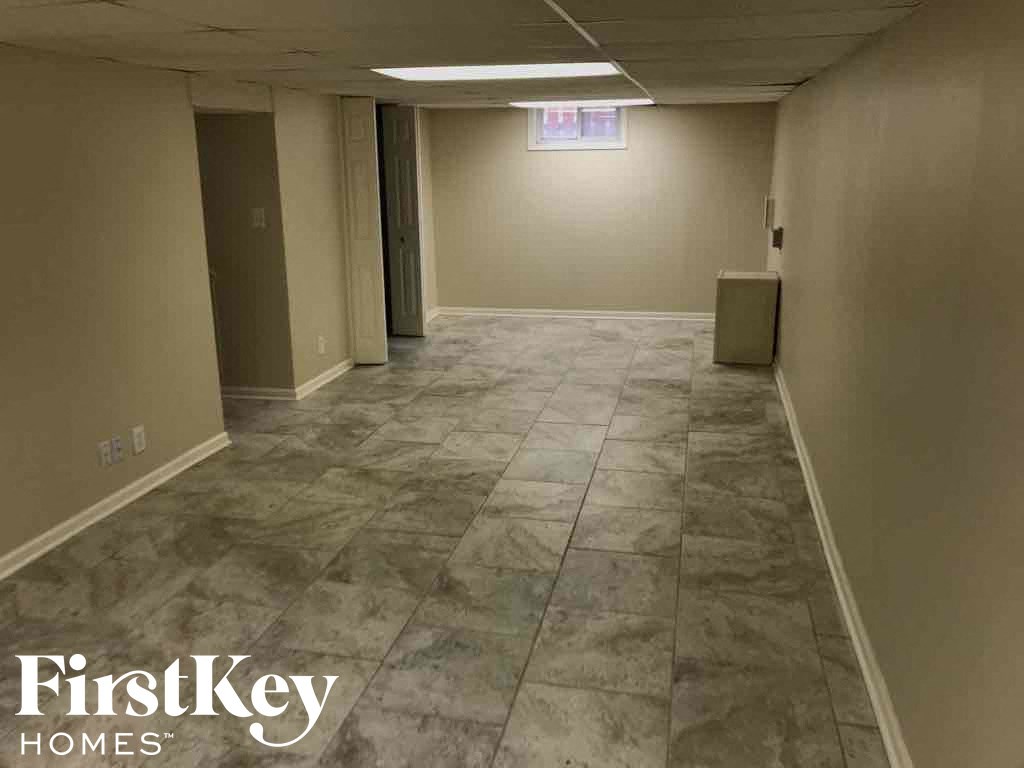 a large empty room with a tile floor in a basement