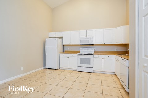 A kitchen with white appliances and cabinets is shown.