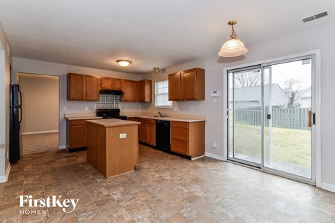 a kitchen with wooden cabinets and a sliding glass door