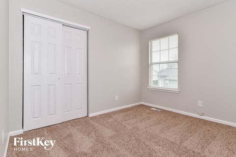 a bedroom with a closet and a door and a window