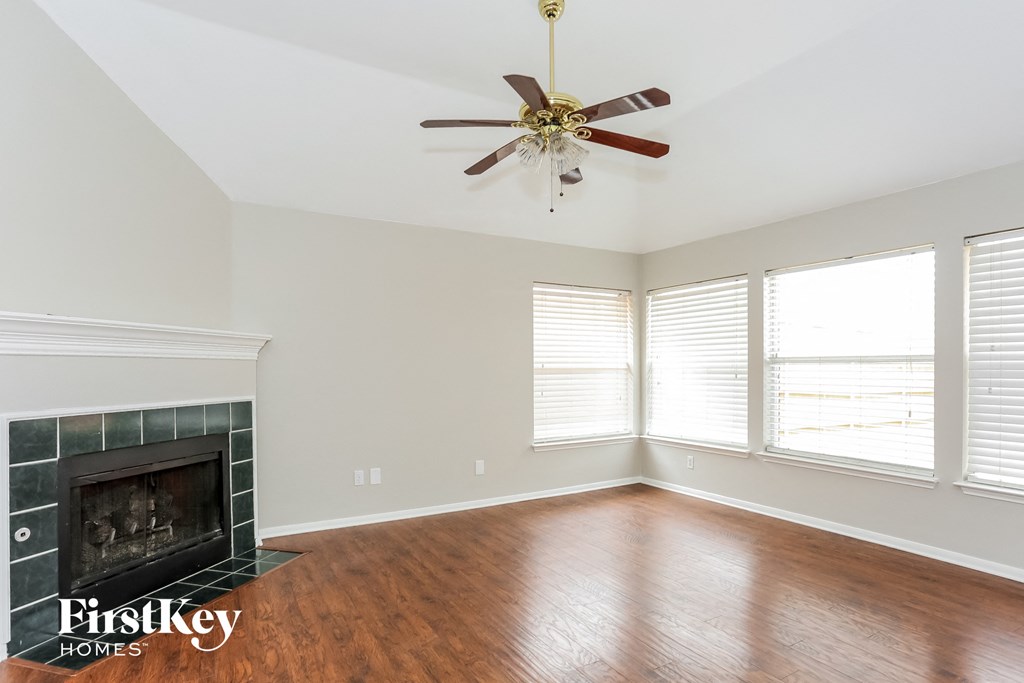 A room with a fireplace and a ceiling fan.