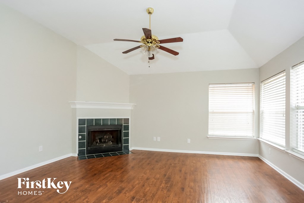 A room with a fireplace and a ceiling fan.