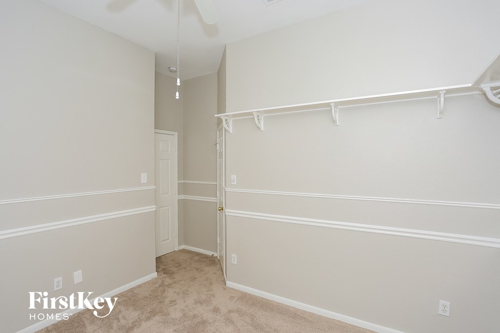 A room with a white ceiling and walls, with a doorway leading to another room.