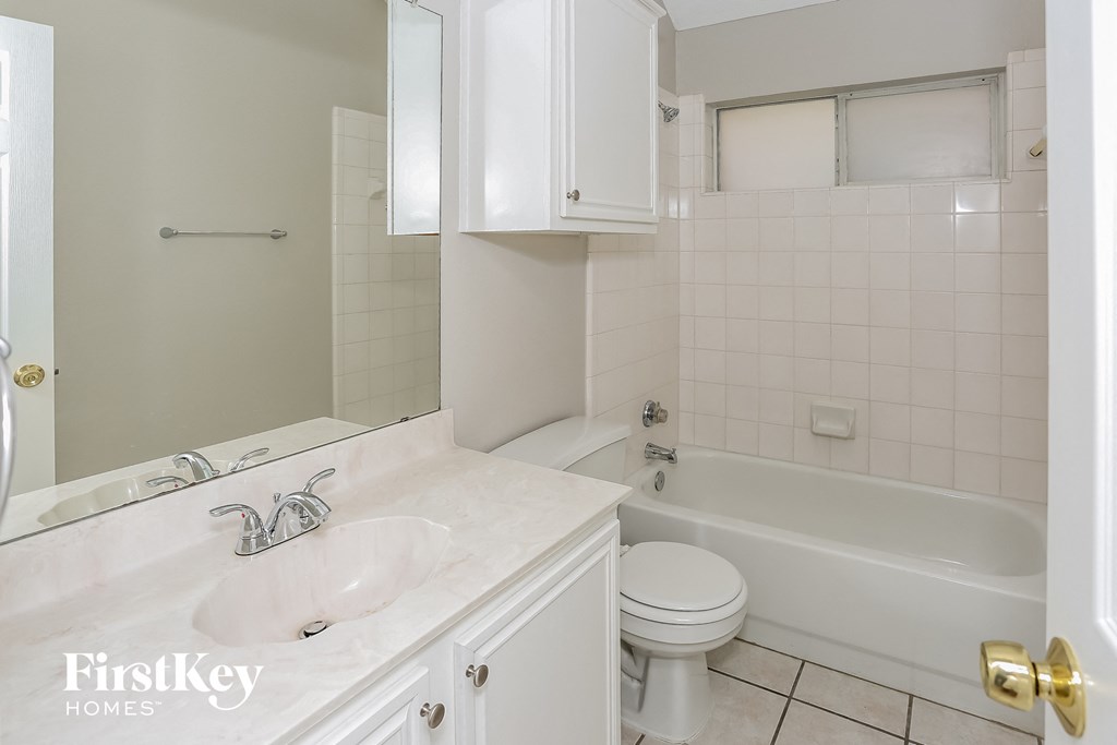 A white bathroom with a sink, toilet and bathtub.