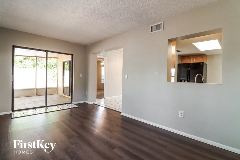 A spacious room with wooden floors and a large window.