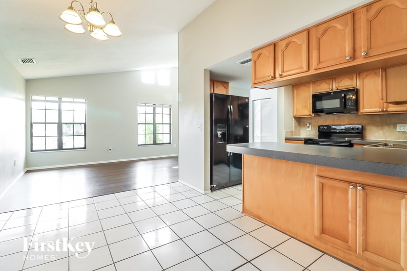 A kitchen with wooden cabinets and black appliances.