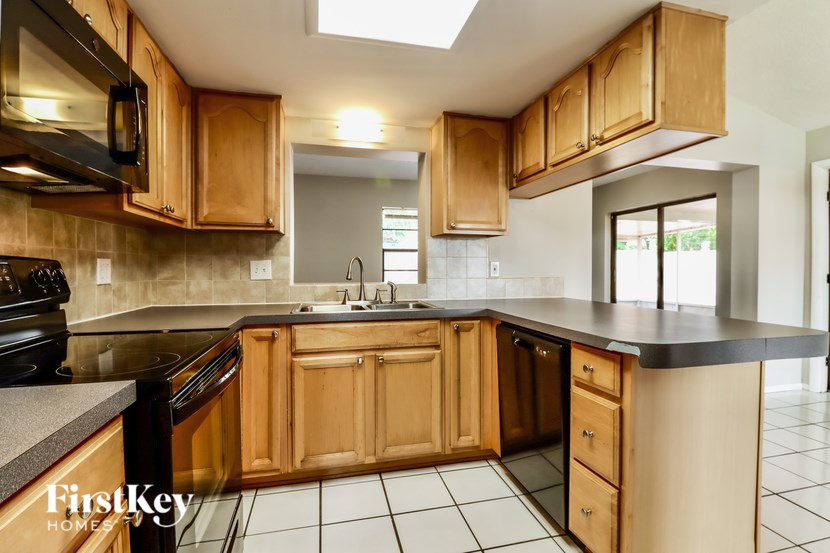 A kitchen with wooden cabinets and black appliances.