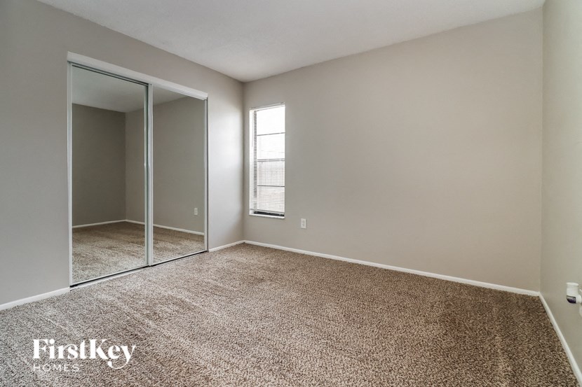 A room with a carpeted floor and a sliding glass door.