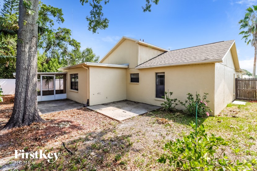 A yellow house with a tree in front of it.