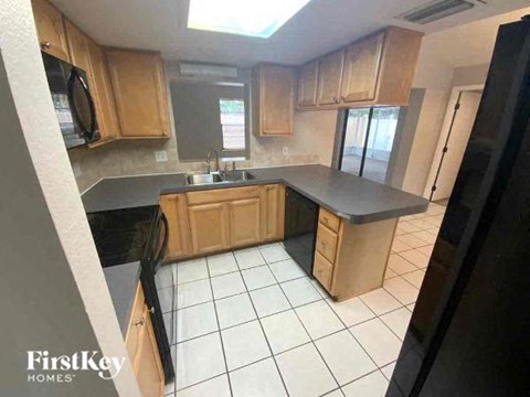 A kitchen with wooden cabinets and black appliances.