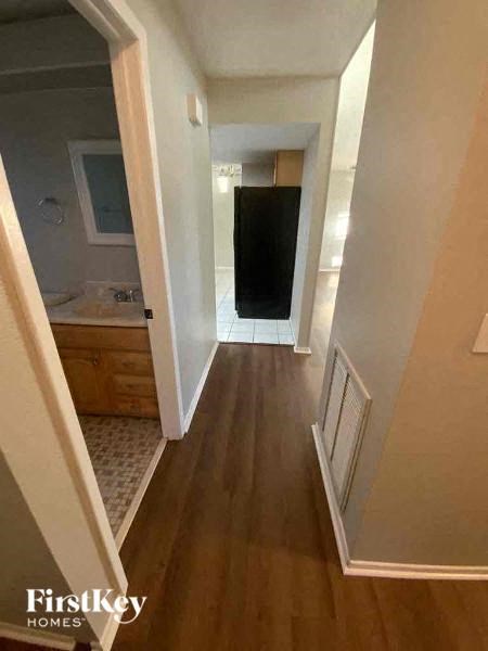 A hallway with wood floors and white walls.