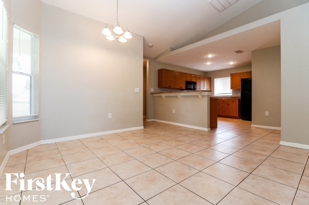 an empty kitchen and living room with tiled flooring