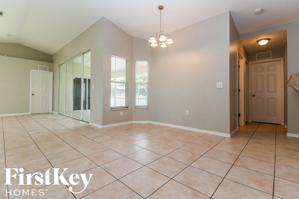 a large empty room with tile floors and a door to a closet