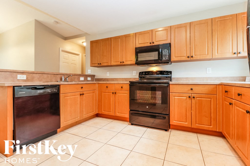 a kitchen with wooden cabinets and black appliances