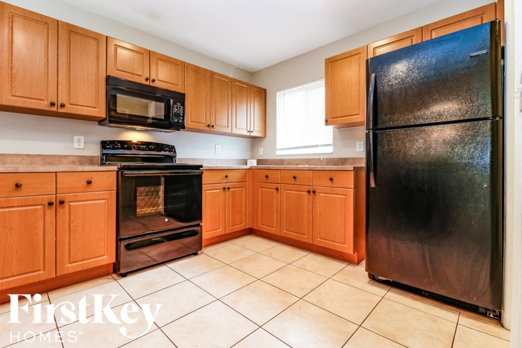 a kitchen with black appliances and wooden cabinets