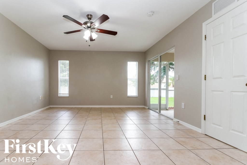 an empty living room with a ceiling fan