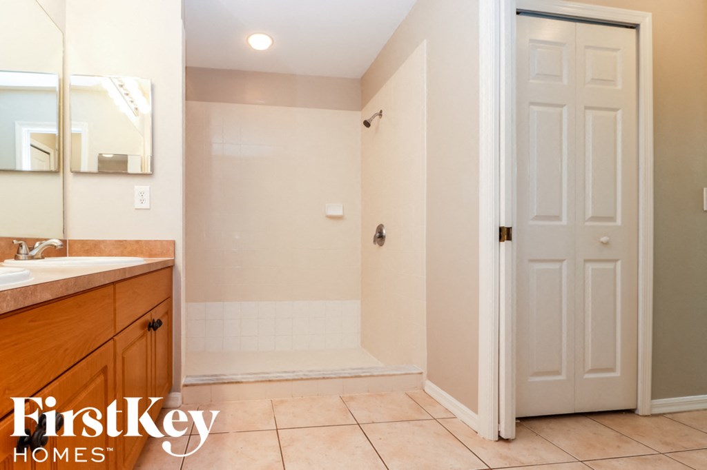 a bathroom with a shower and a sink and a mirror