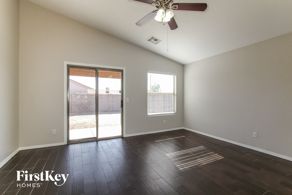 an empty living room with a sliding glass door to a patio