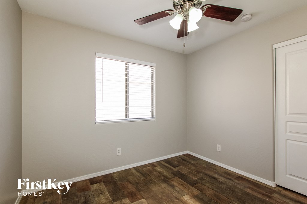 a bedroom with a ceiling fan and a window