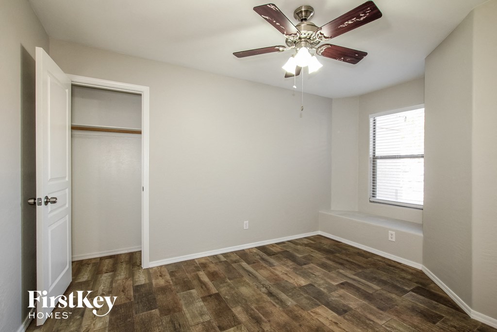 a bedroom with a ceiling fan and a closet