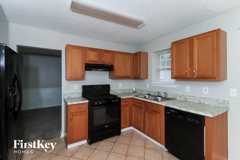 A kitchen with wooden cabinets and black appliances.