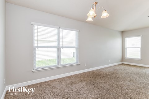 a bedroom with two windows and a carpeted floor
