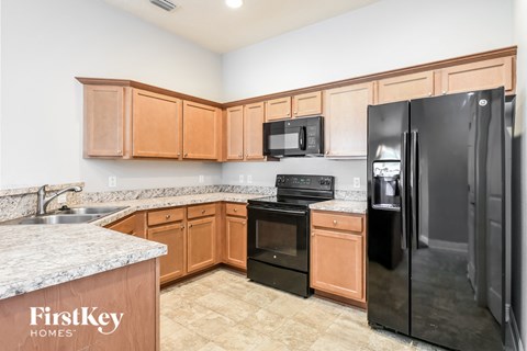 a kitchen with black appliances and wooden cabinets