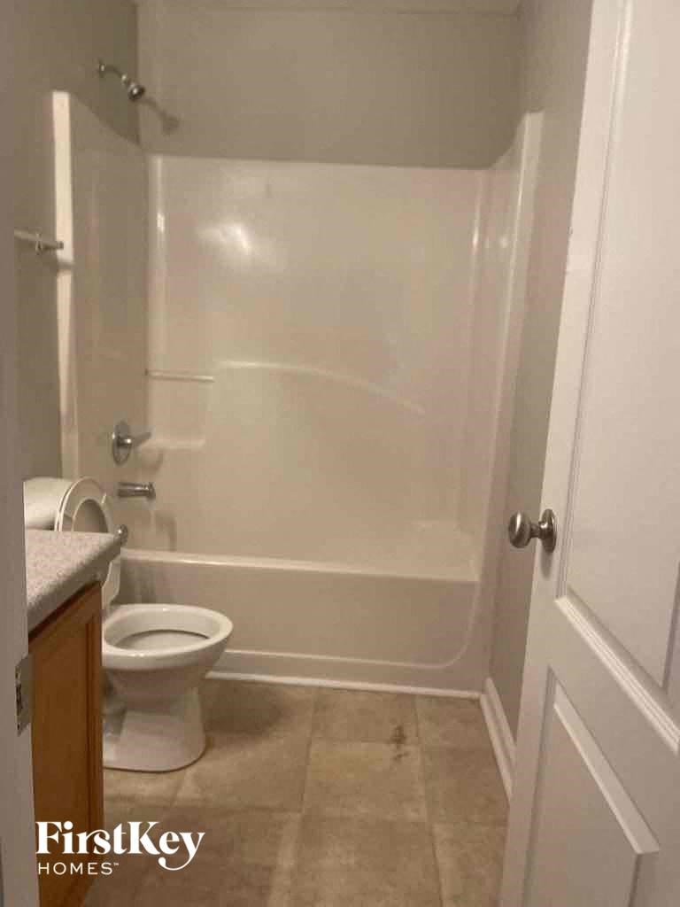 a white bathroom with a toilet and a shower