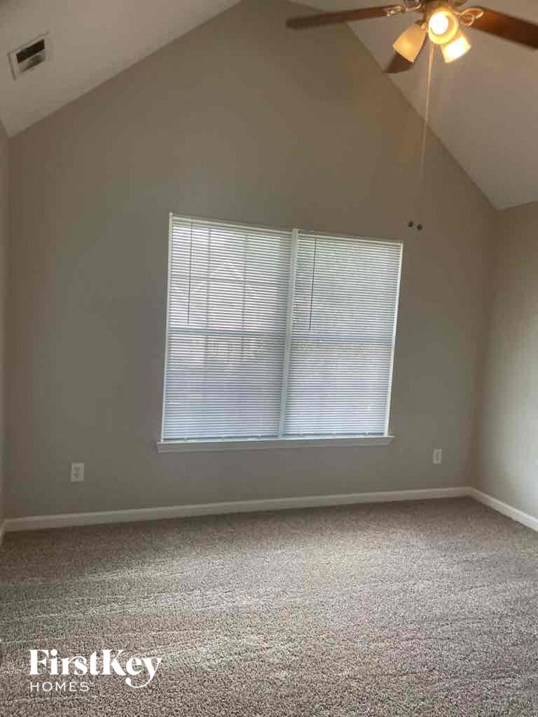 a bedroom with a window and a ceiling fan