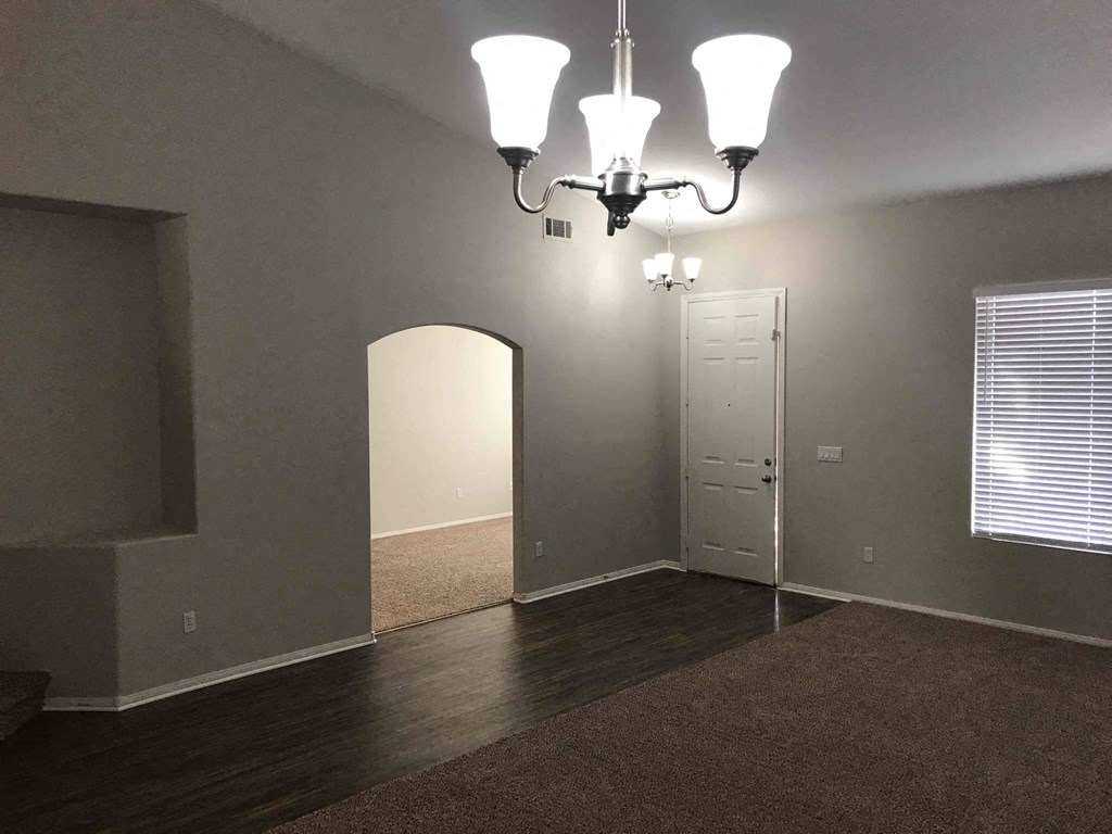 A room with a chandelier and a door.