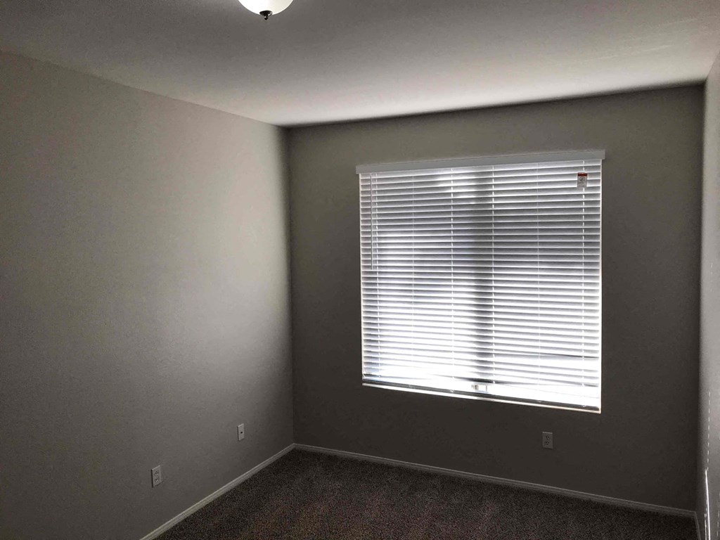 A room with a window covered in blinds.