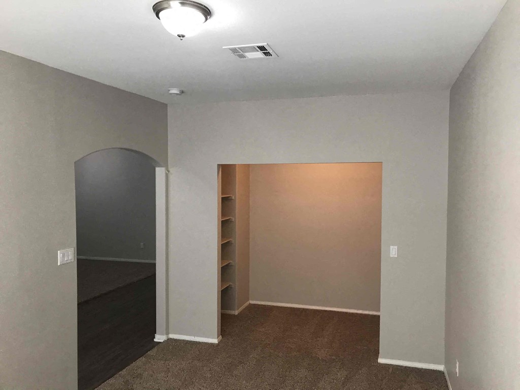 A room with a carpeted floor and a light on the ceiling.