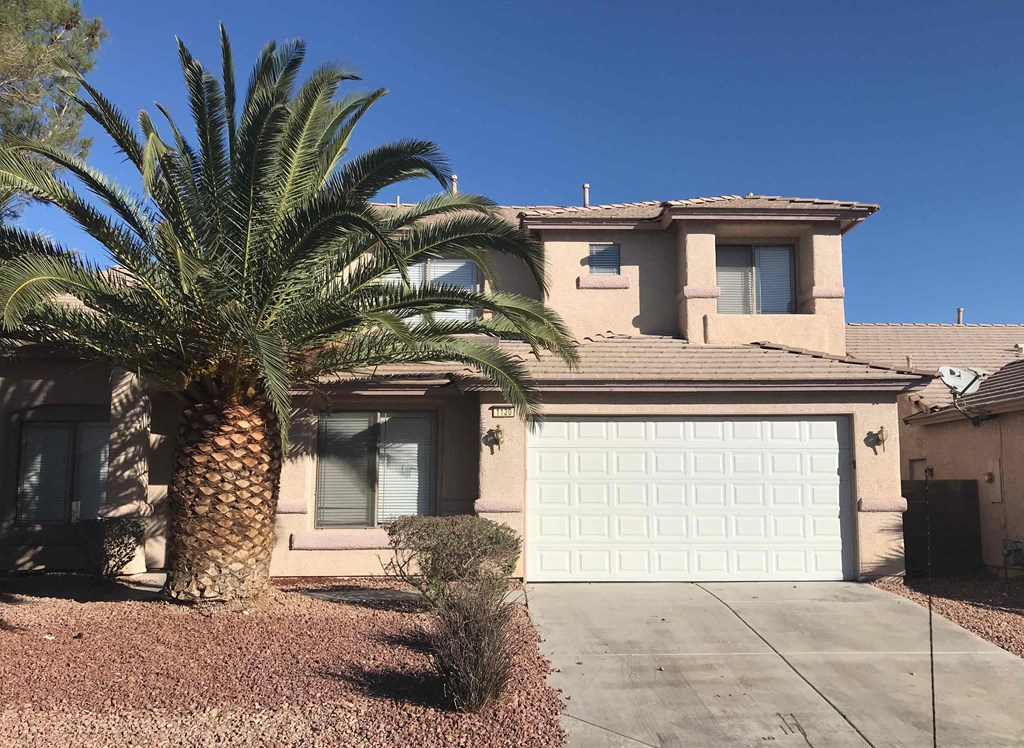A house with a palm tree in front.
