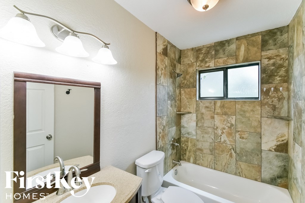 a bathroom with a tub and a sink and a toilet