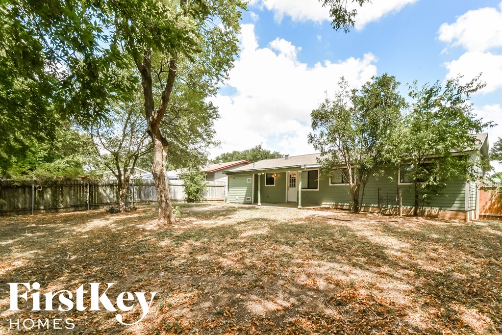 a green house with a yard and trees