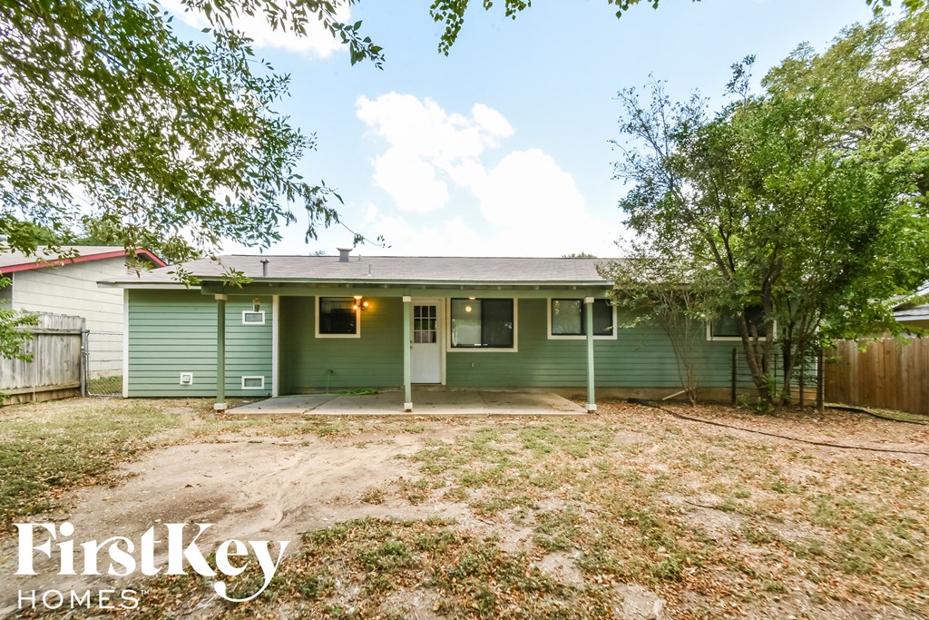a green house with a yard and trees