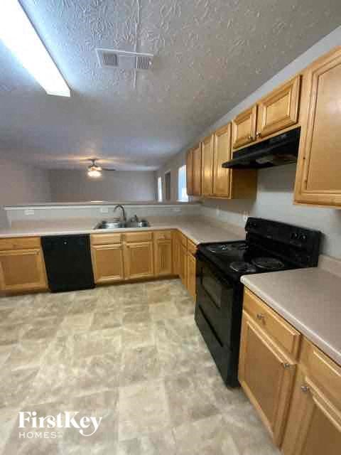 a kitchen with wooden cabinets and a black stove