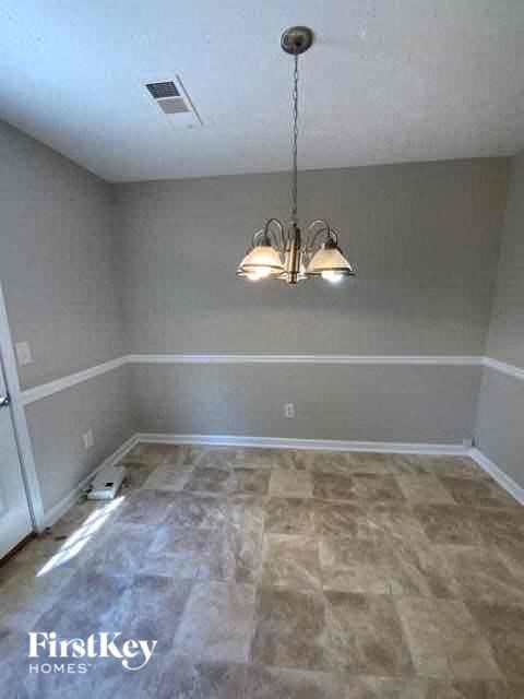 a empty room with a chandelier and a wooden floor